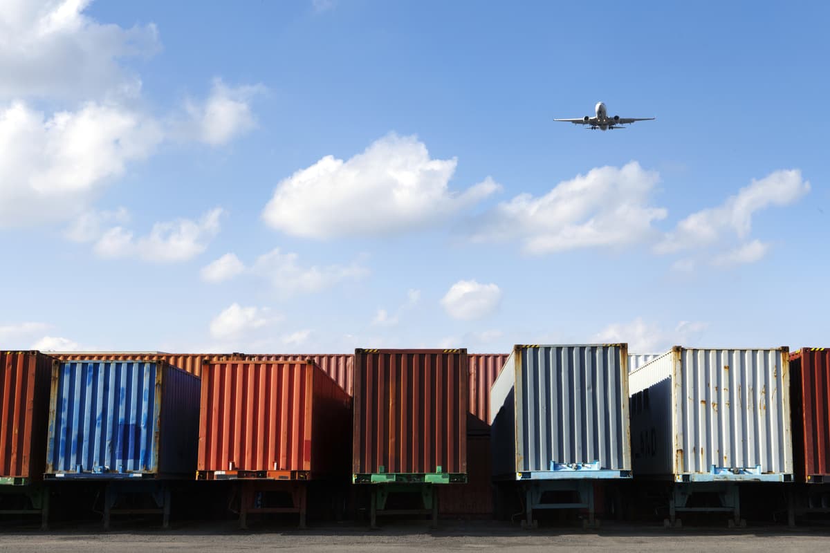 Plane flying over cargo containers