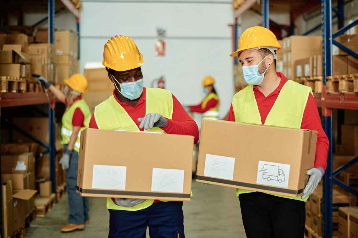 Multiracial Warehouse Workers Carrying Box